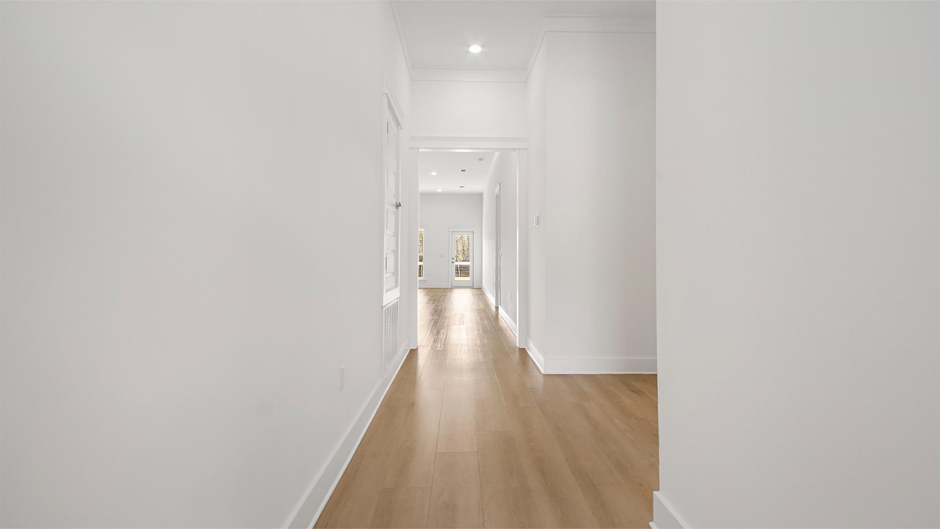 Foyer with tall ceilings and EVP flooring and a plenty of natural light and hallway to guest bedrooms.