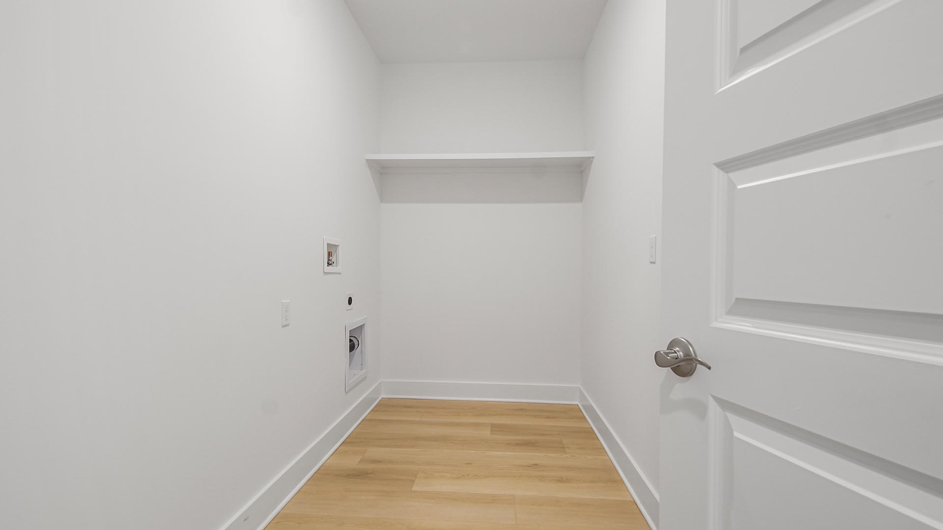 Laundry room with EVP flooring and wood shelf.