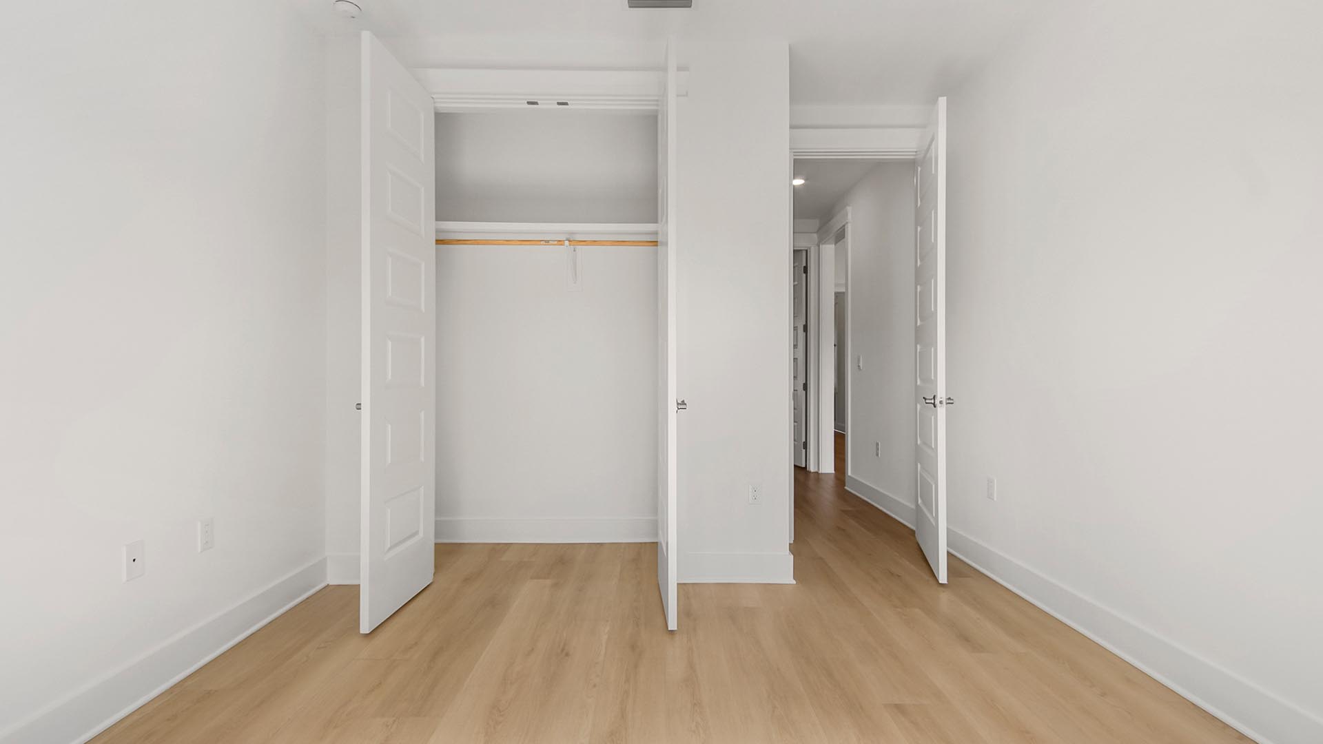 Bedroom four with EVP flooring and double door closet with wooden shelving.