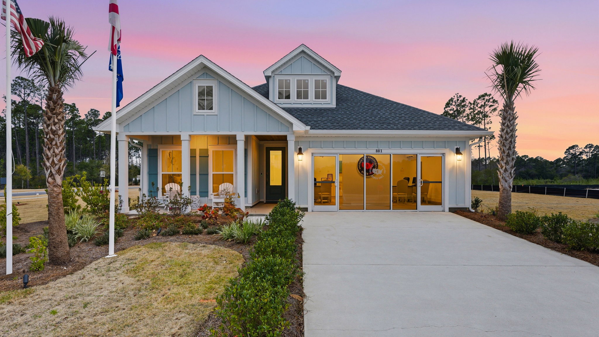 The model home at twilight with interior lighting on