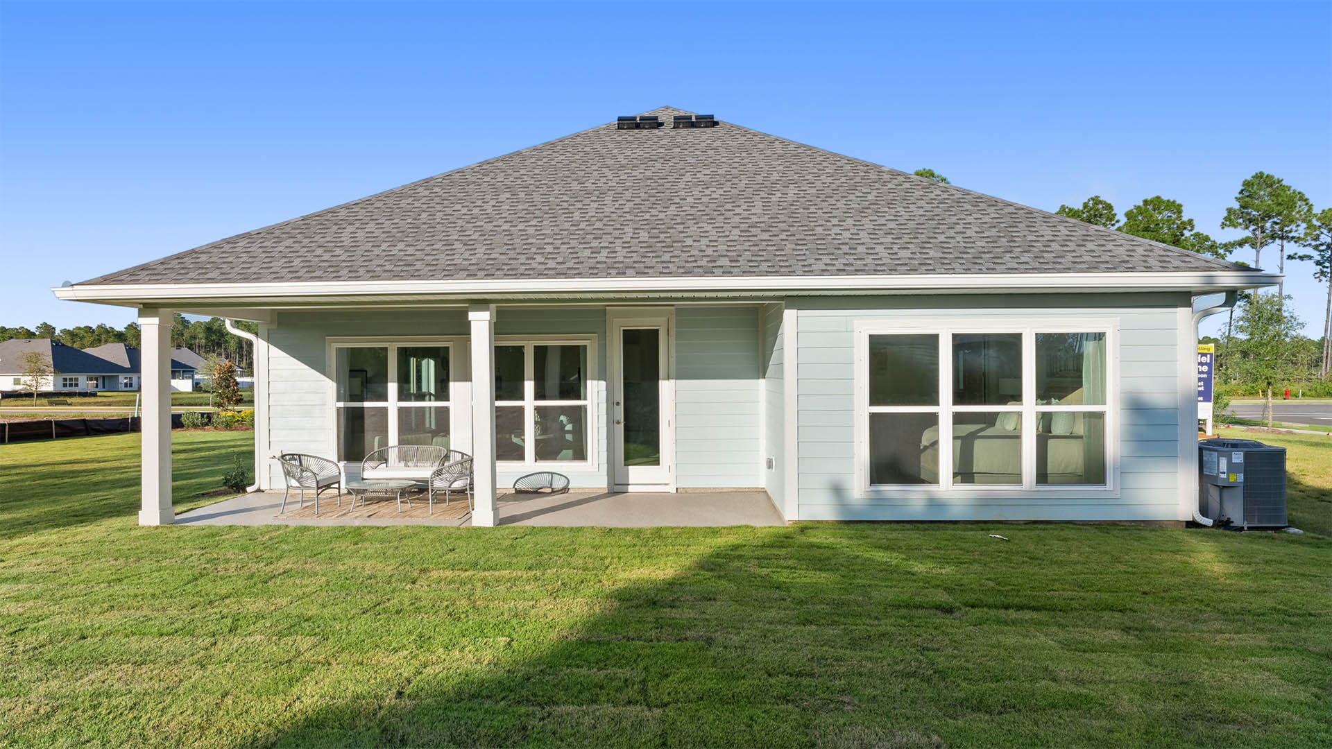 There is a covered patio at the back of the home and spanning windows that allow natural light to fill the living space