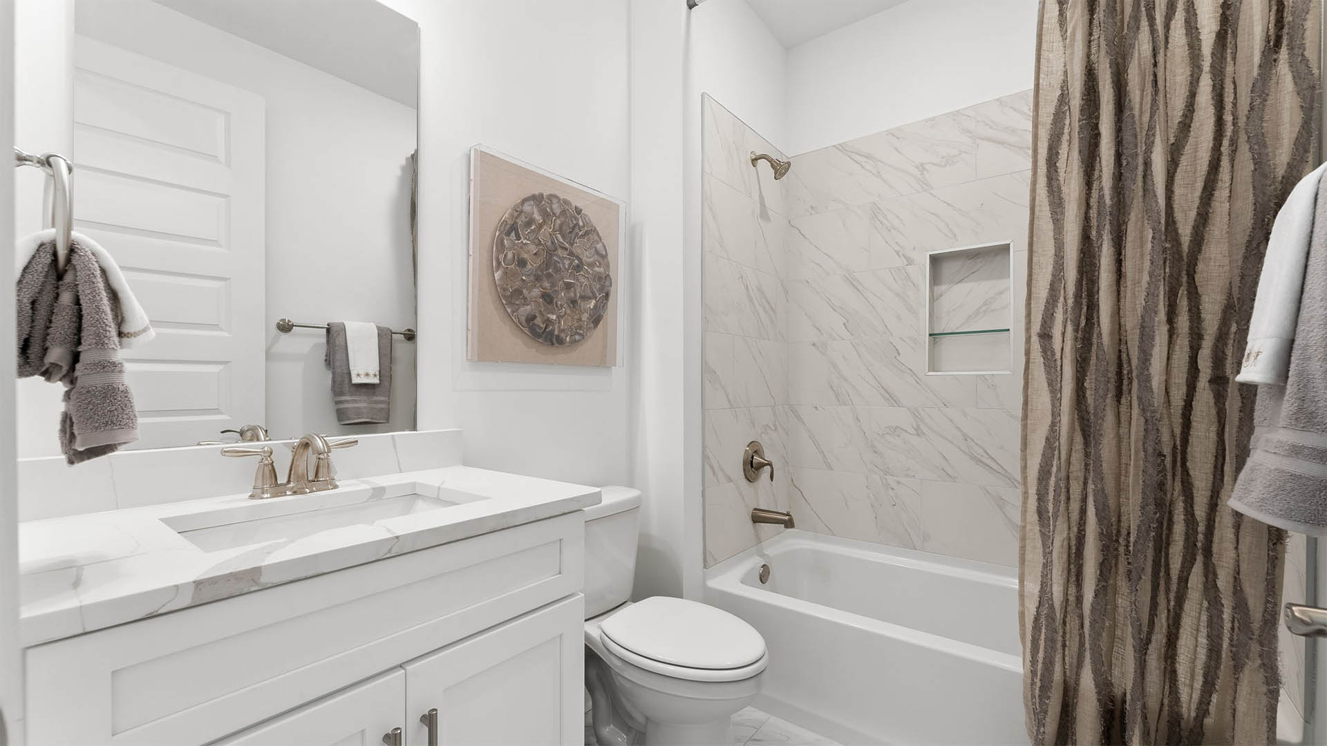 The guest bedrooms are separate by a shared bath that has a single vanity and shower tub combination