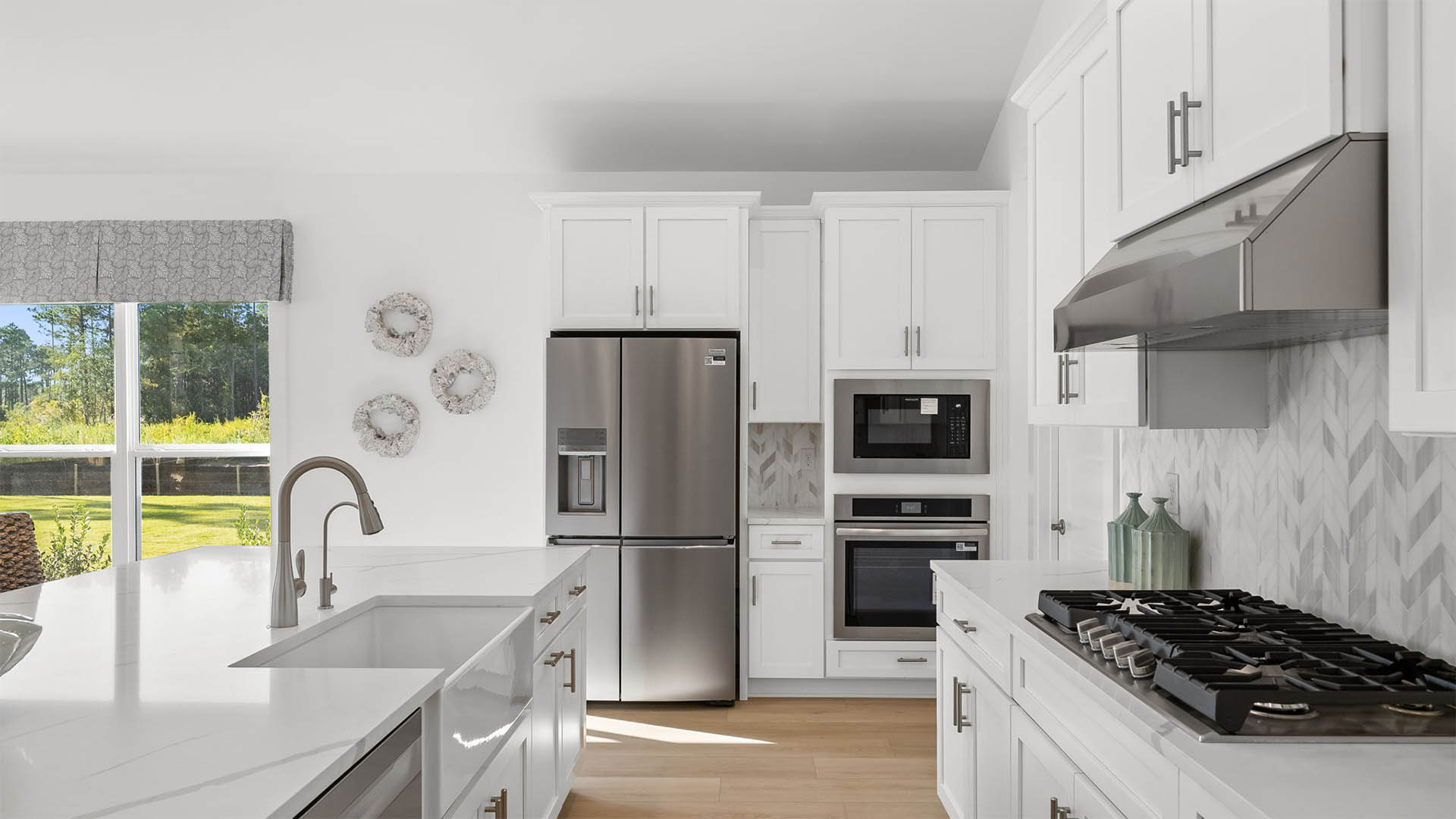 The kitchen is a chefs dream with gas cooktop stove, mounted oven and microwave as well as upper and lower cabinetry for storage