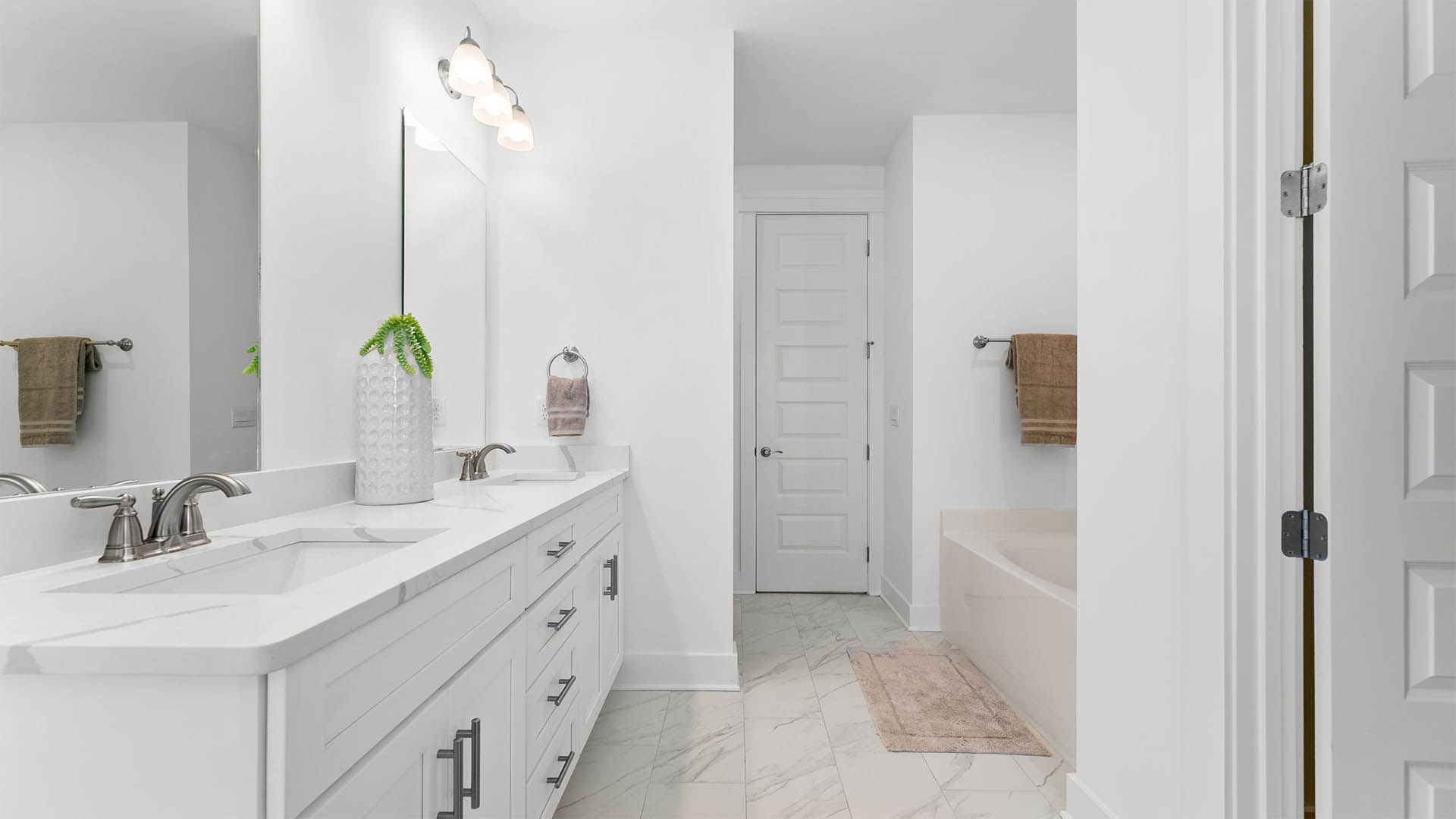 The primary bathroom is a space of elegance with quartz countertops a dual sink vanity and lower cabinetry for storage