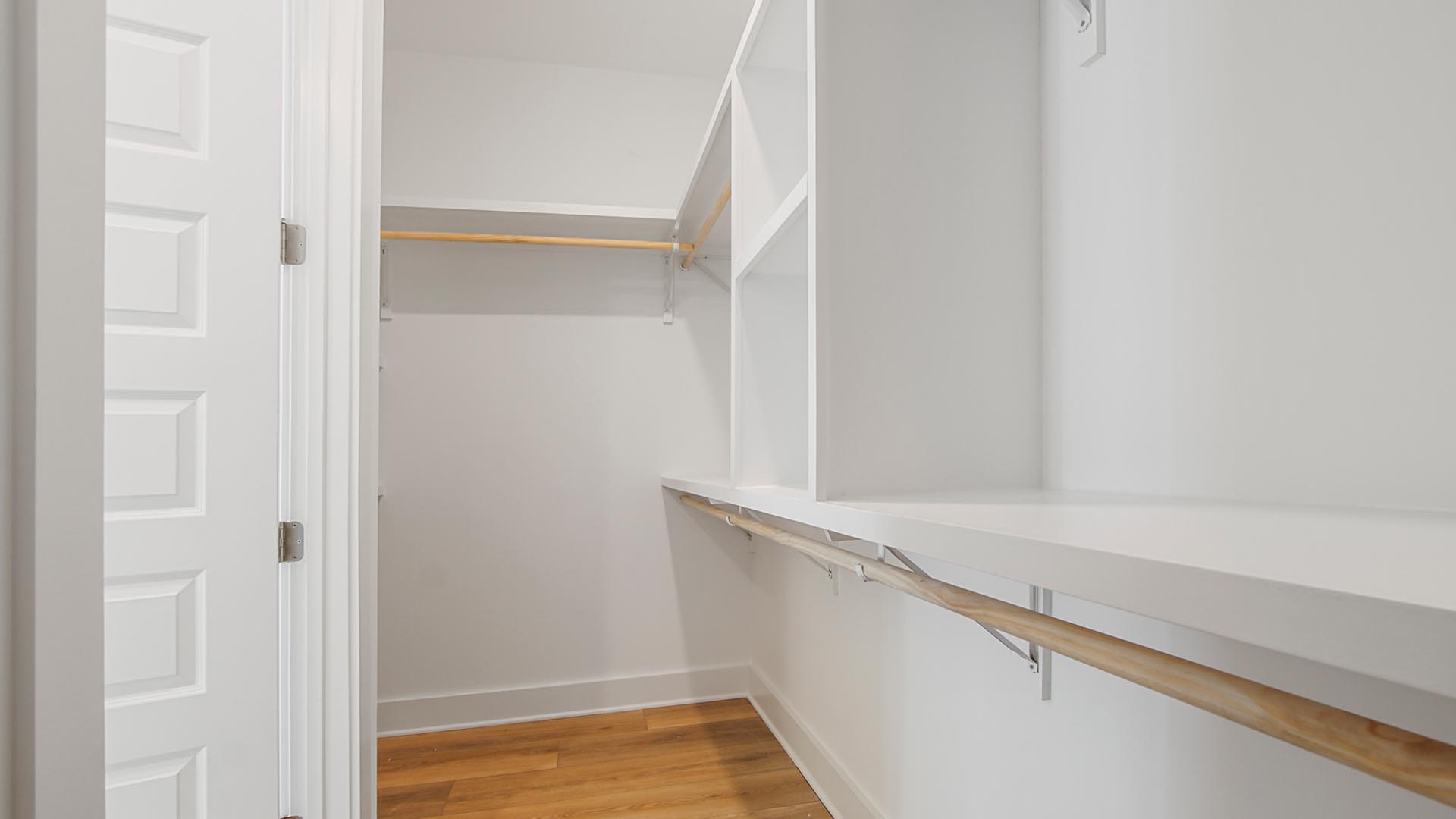 The generous size closet in the primary bathroom has EVP floors and wood shelving