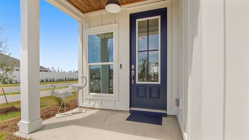 Breakfast Point Islamorada plan model home covered front entrance with accent wood ceiling.