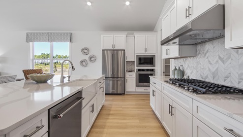 The kitchens are appointment with gourmet appliances including a gas cooktop and hood vent