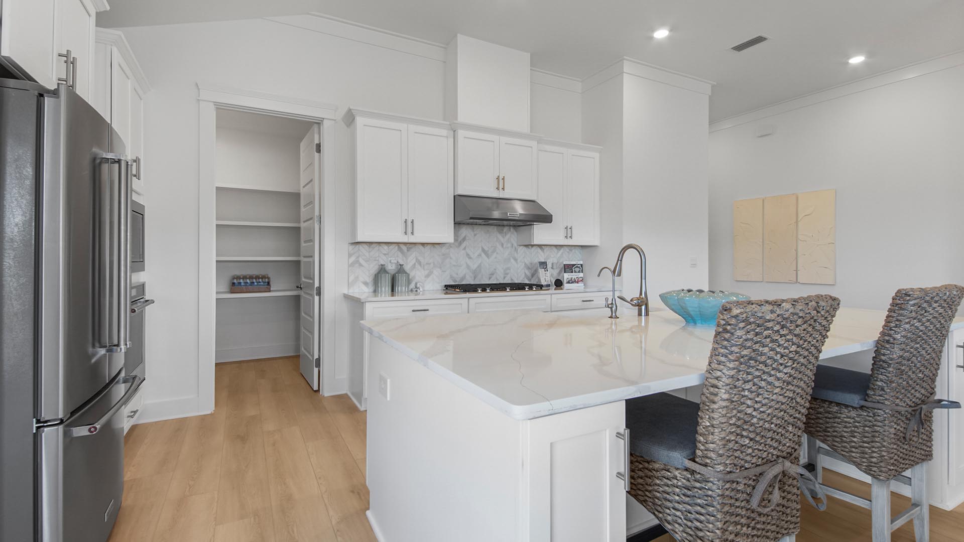 The kitchen features a sizeable pantry that is finished with wood shelving