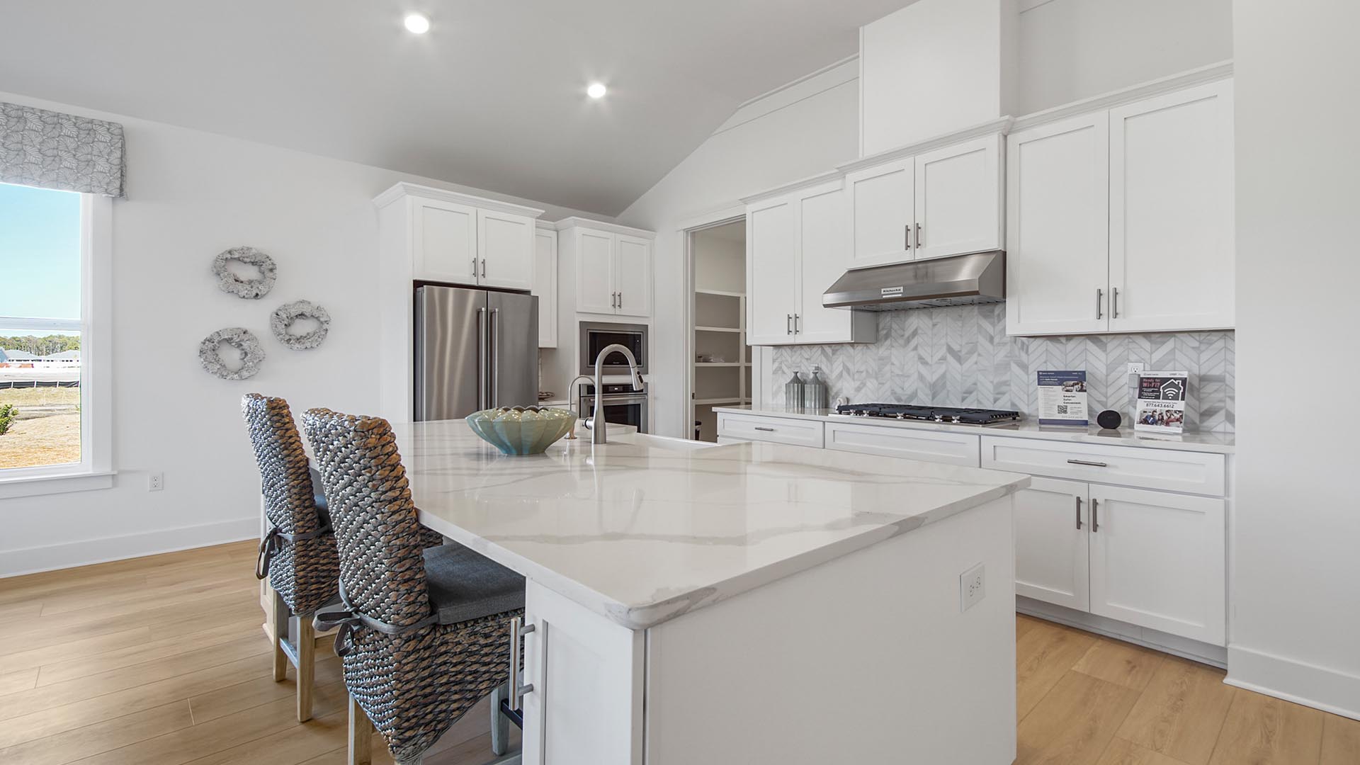 The kitchen has been elegantly styled with quartz countertops and beautiful white cabinetry