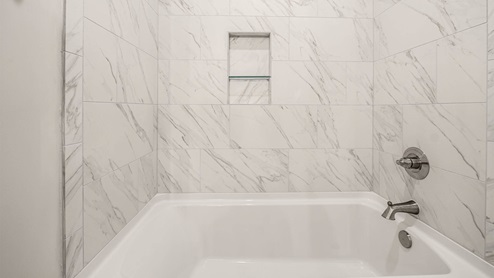 Bathroom with white tile shower.