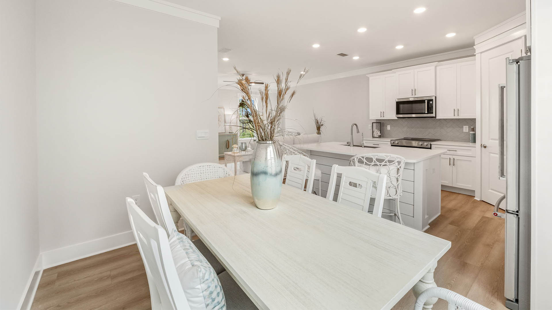 Dining room with table and kitchen island with quartz countertops.
