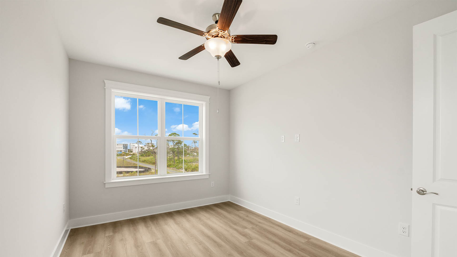 Bedroom with ceiling fan and EVP flooring.