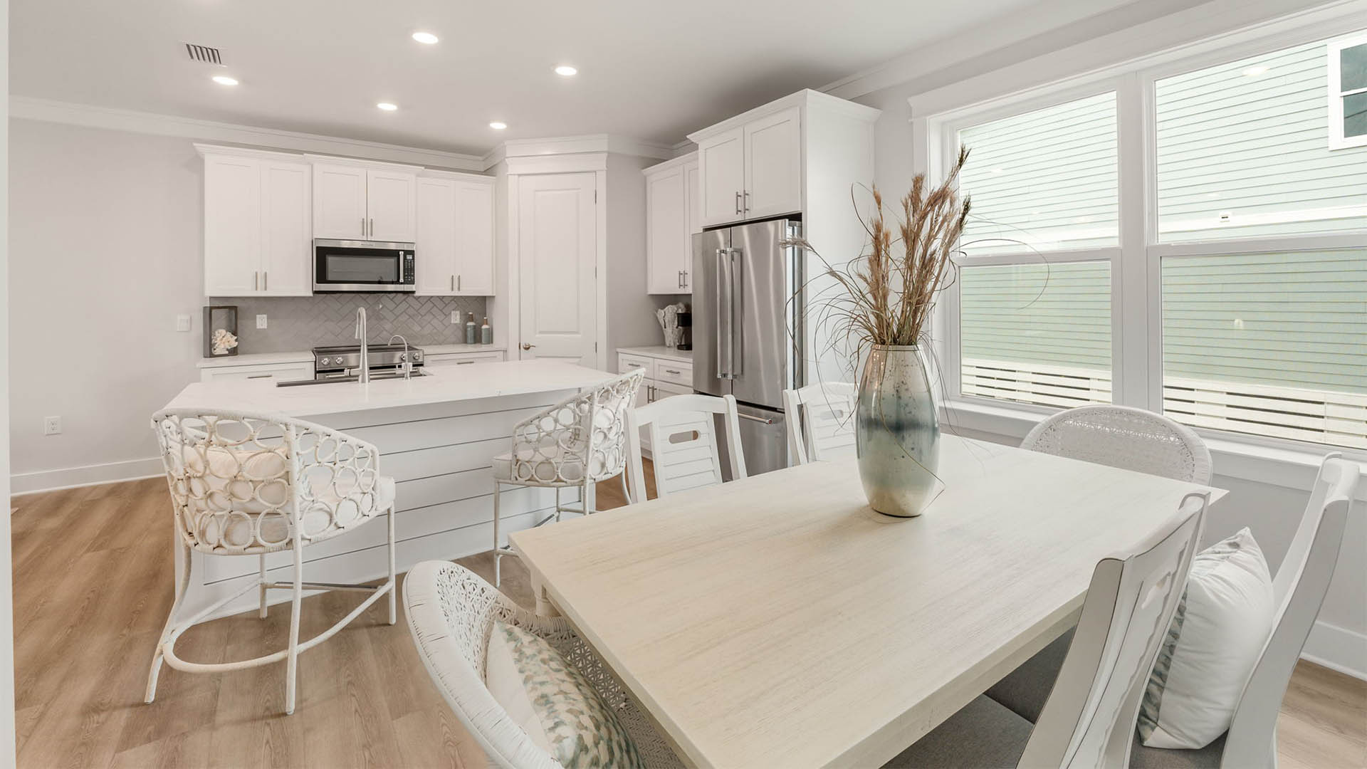 Dining room with table and kitchen island with quartz countertops.