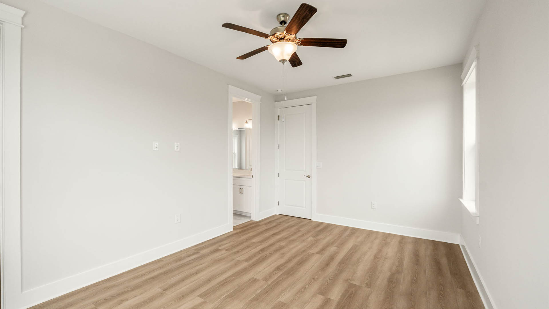 Bedroom with ceiling fan and EVP flooring.
