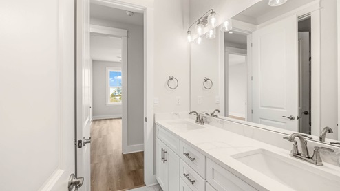 Bathroom with double-vanity and quartz countertops.