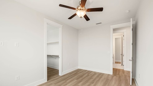 Bedroom with ceiling fan and EVP flooring.