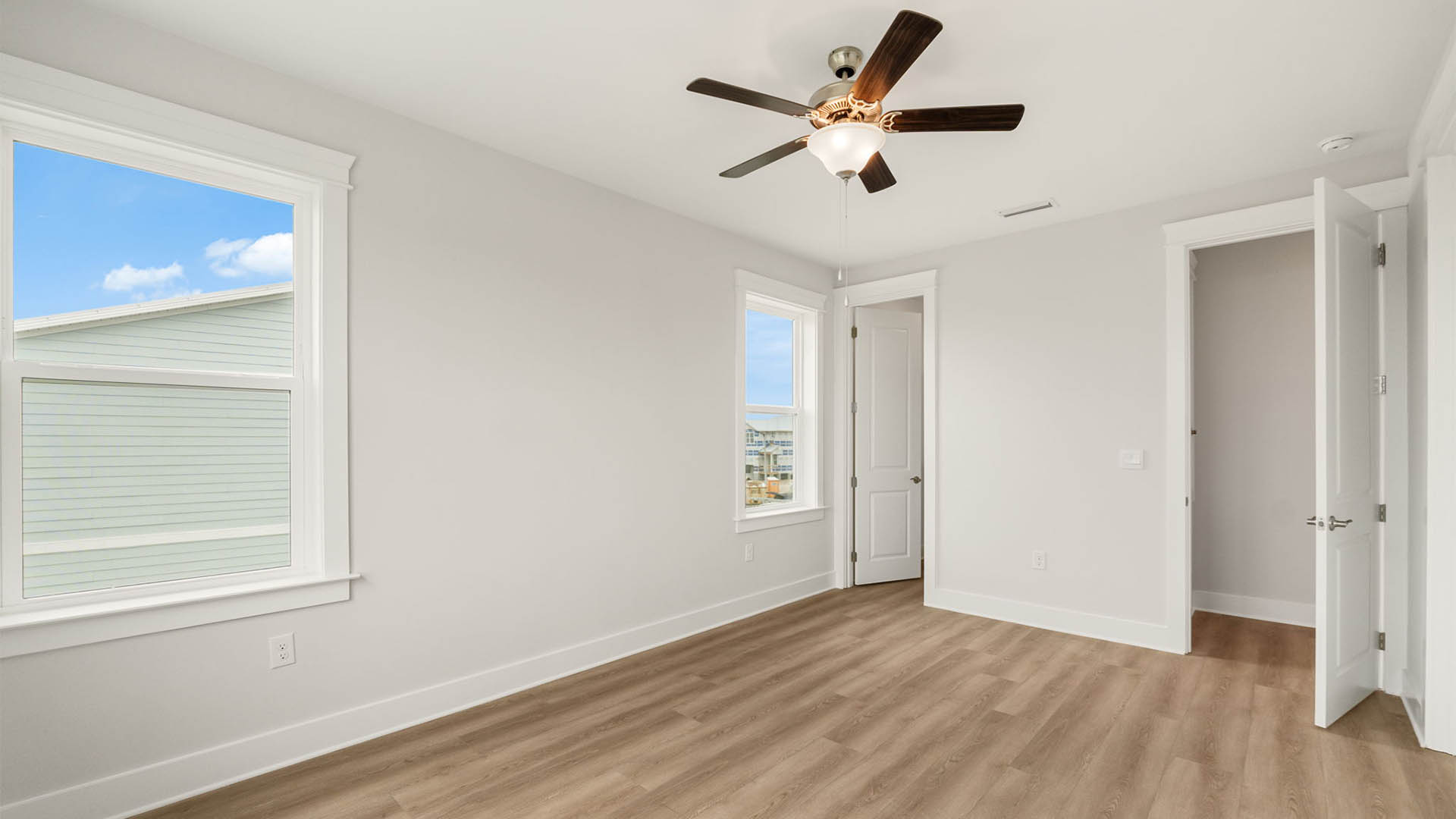 Bedroom with ceiling fan and EVP flooring.
