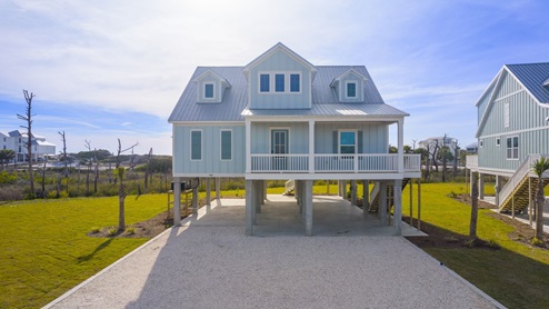 Luxury 2-story home on pilings with covered front porch.