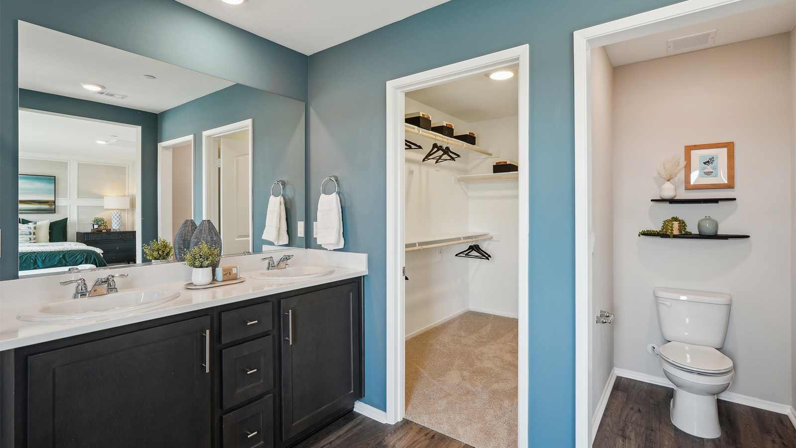 Primary bathroom with dual vanities and walk-in closet
