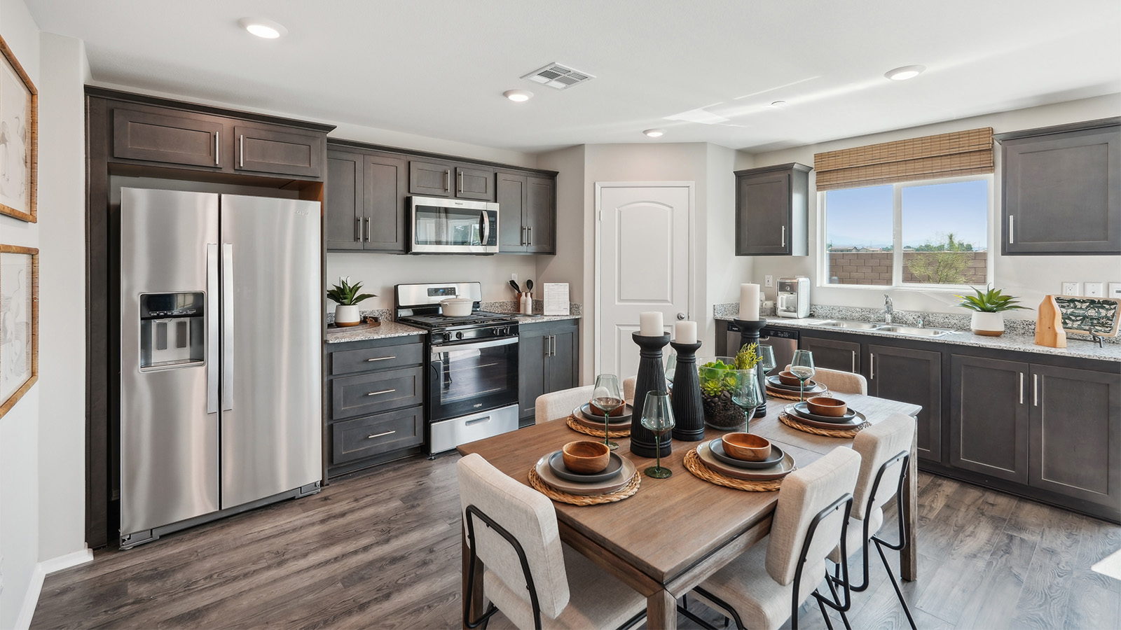Open-concept kitchen with dark cabinets and granite countertops