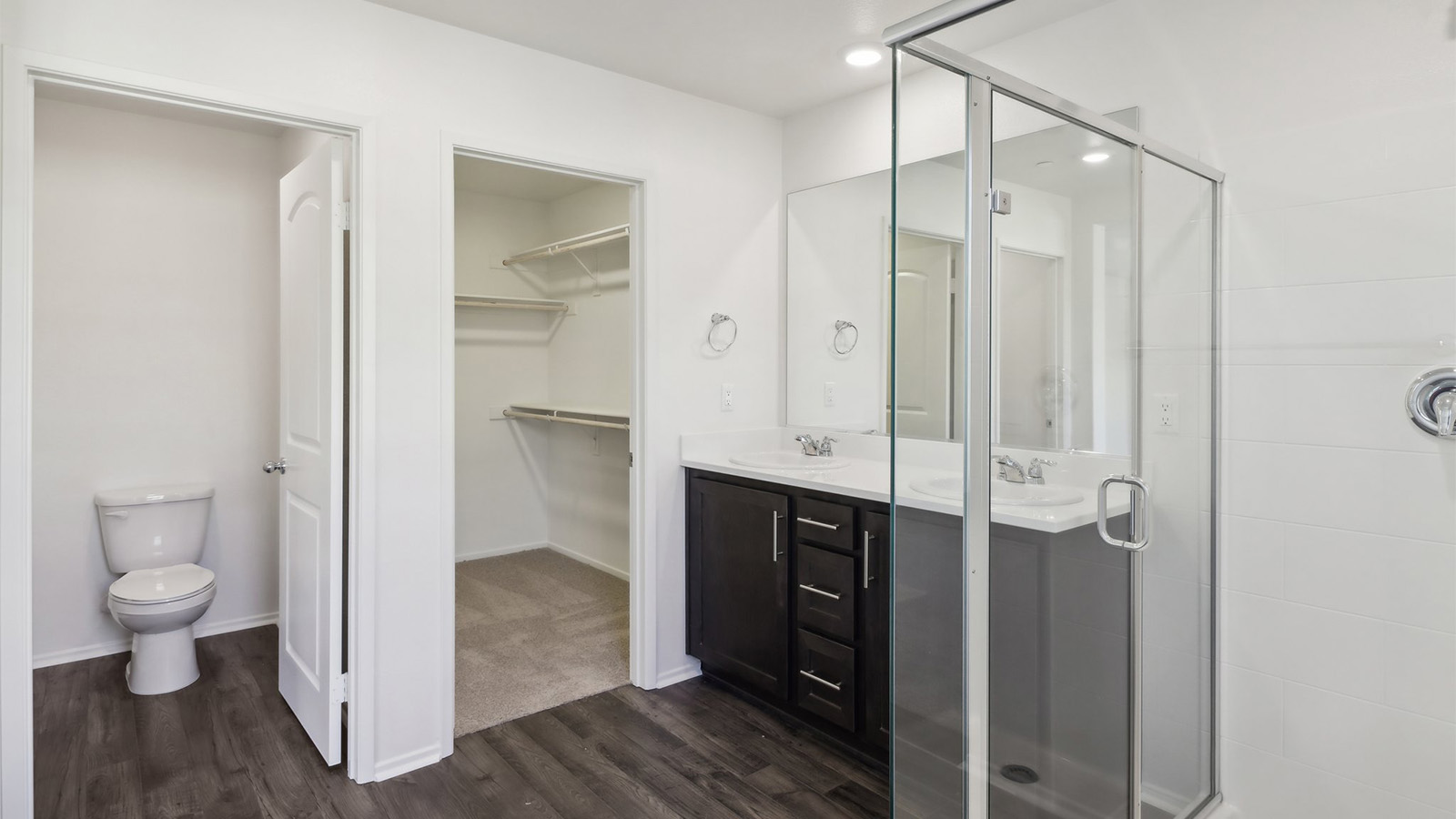 Primary bathroom with dual vanities and shower