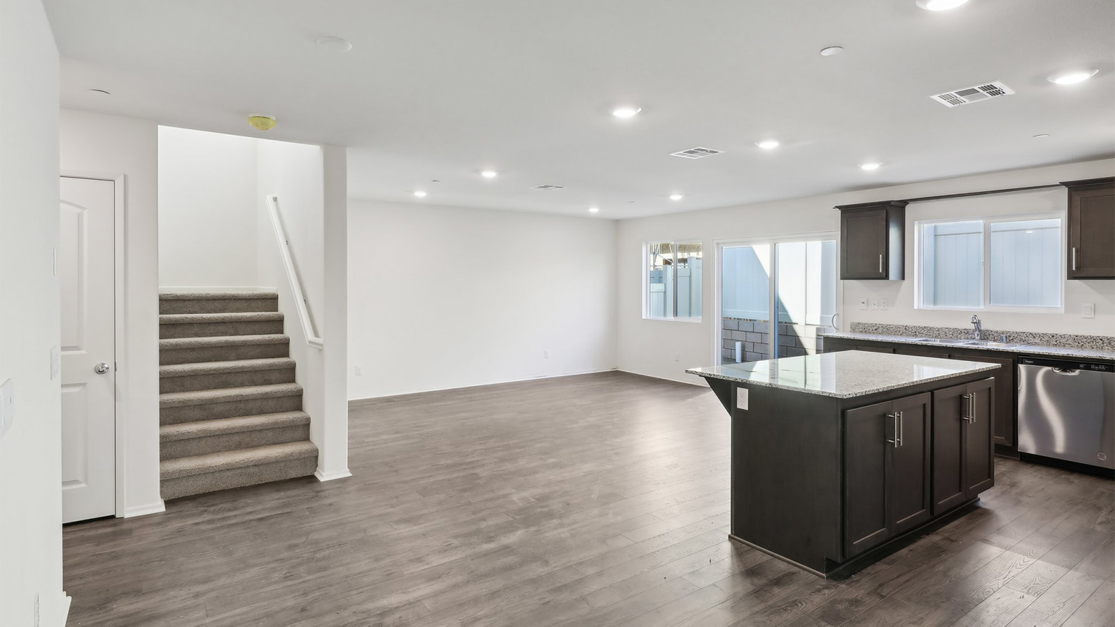 Open kitchen with dark cabinets granite countertops and stainless steel appliances