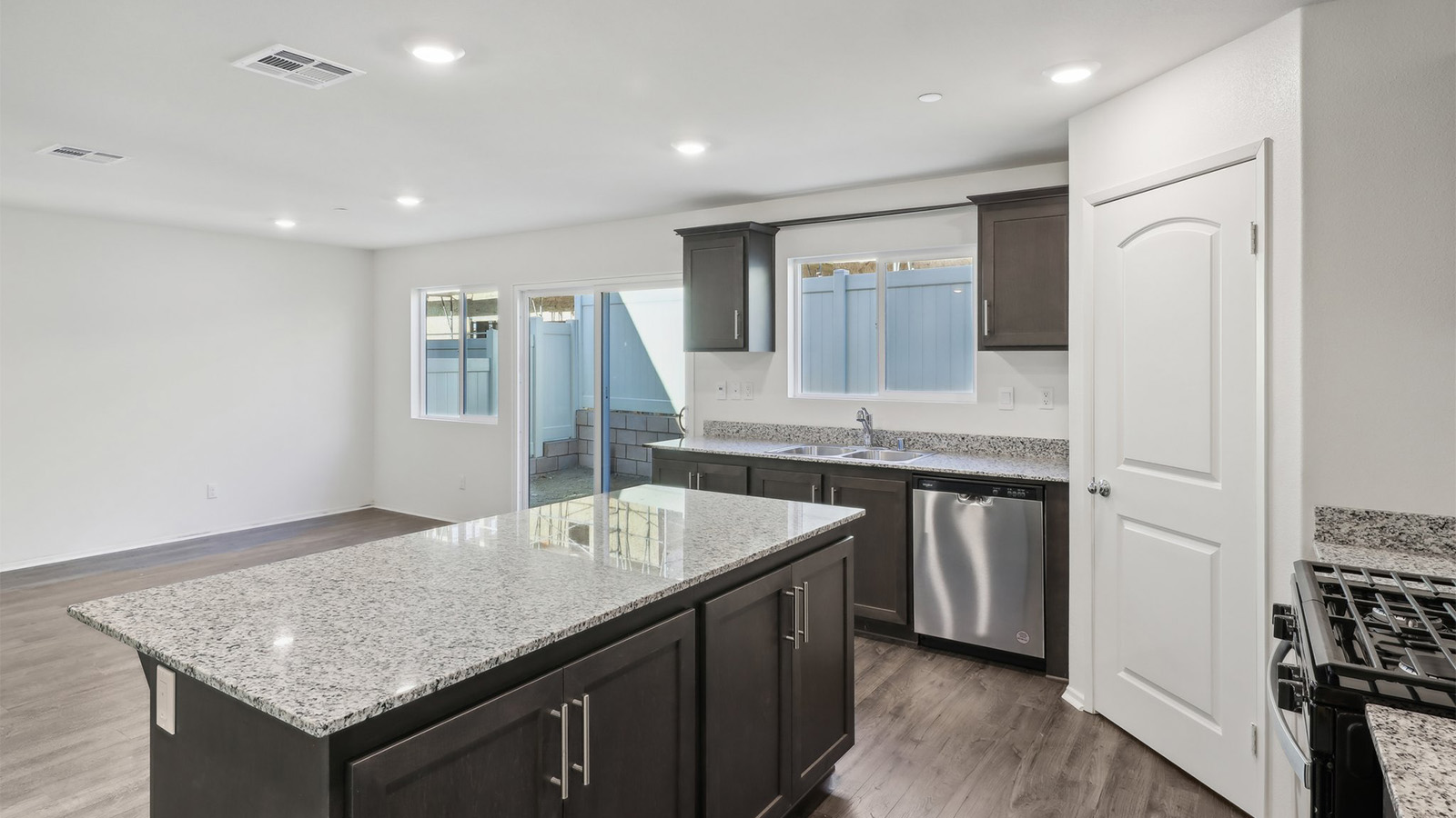 Open kitchen with dark cabinets granite countertops and stainless steel appliances