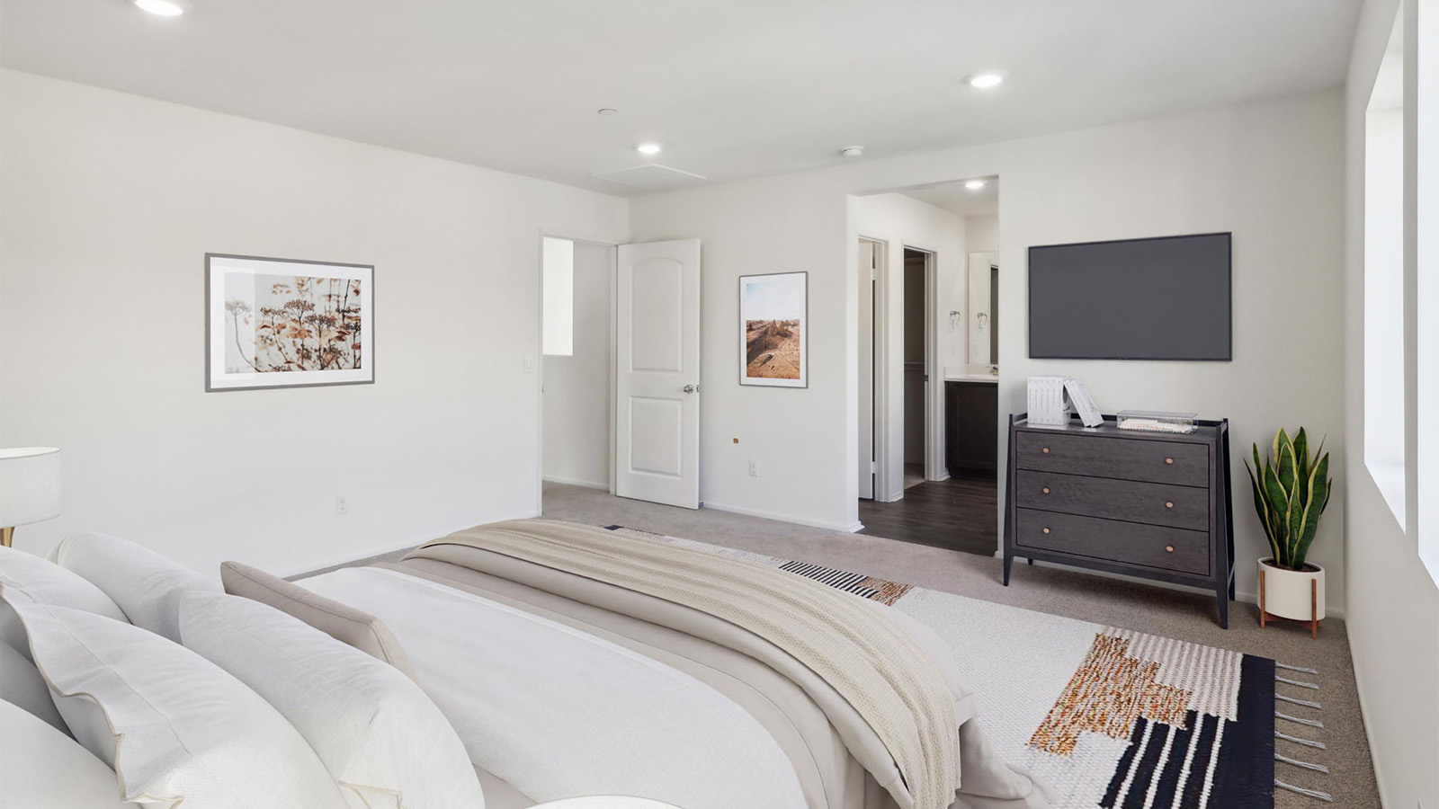 Primary bedroom with king bed and carpet