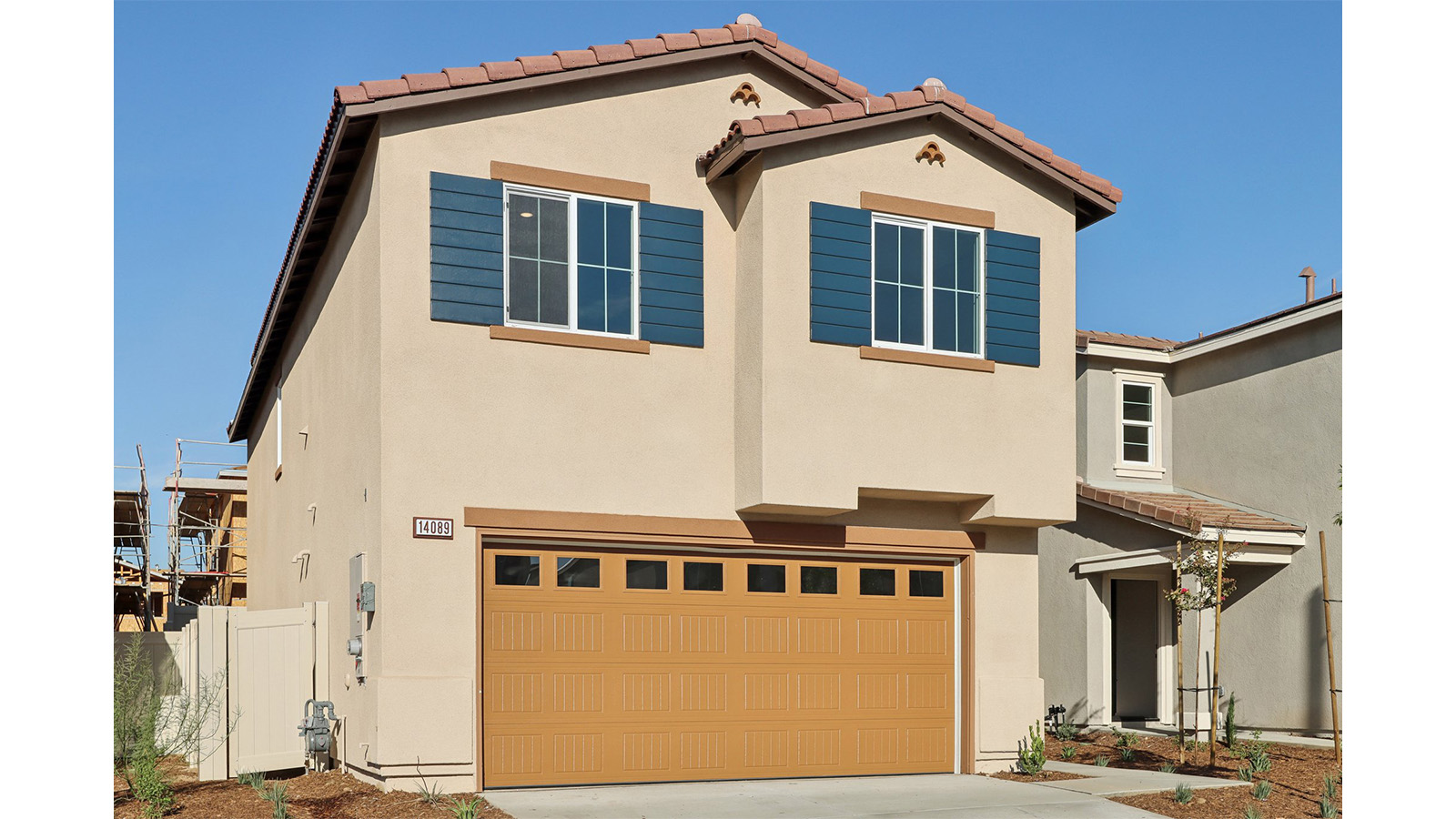 Two-story Spanish home with shutters and two car garage