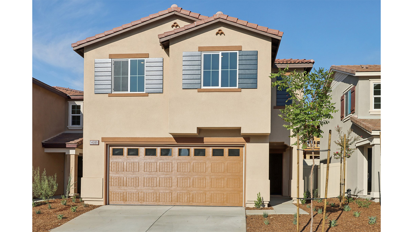Two-story Spanish home with shutters and two car garage
