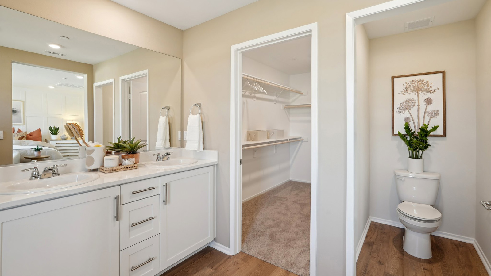 Primary bathroom with dual vanities and walk-in closet