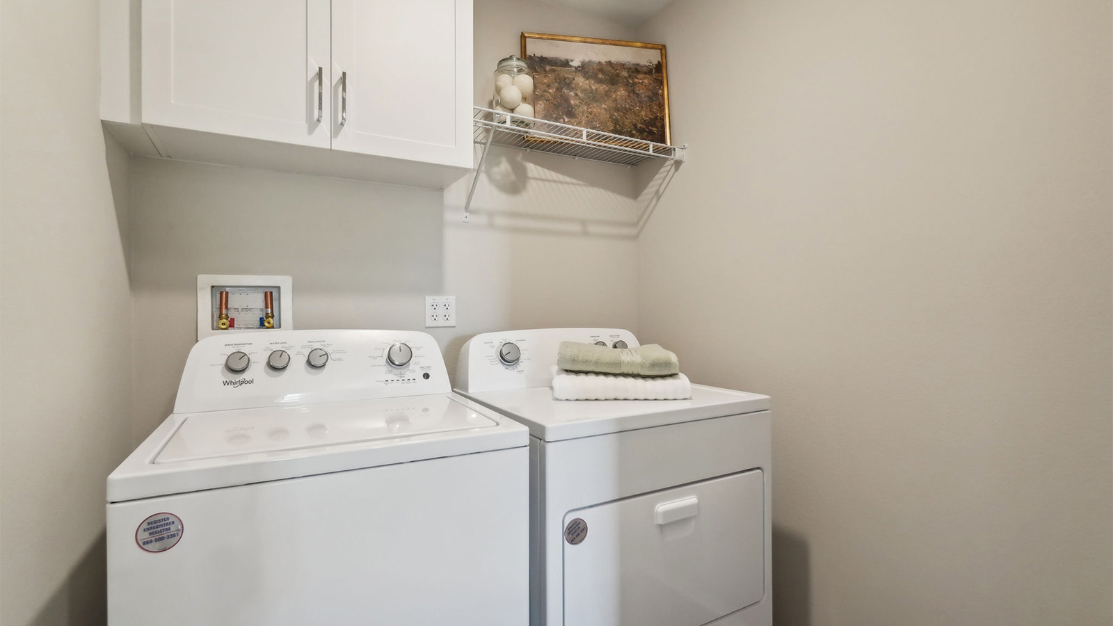Laundry room with upper cabinet and shelf and washer and dryer