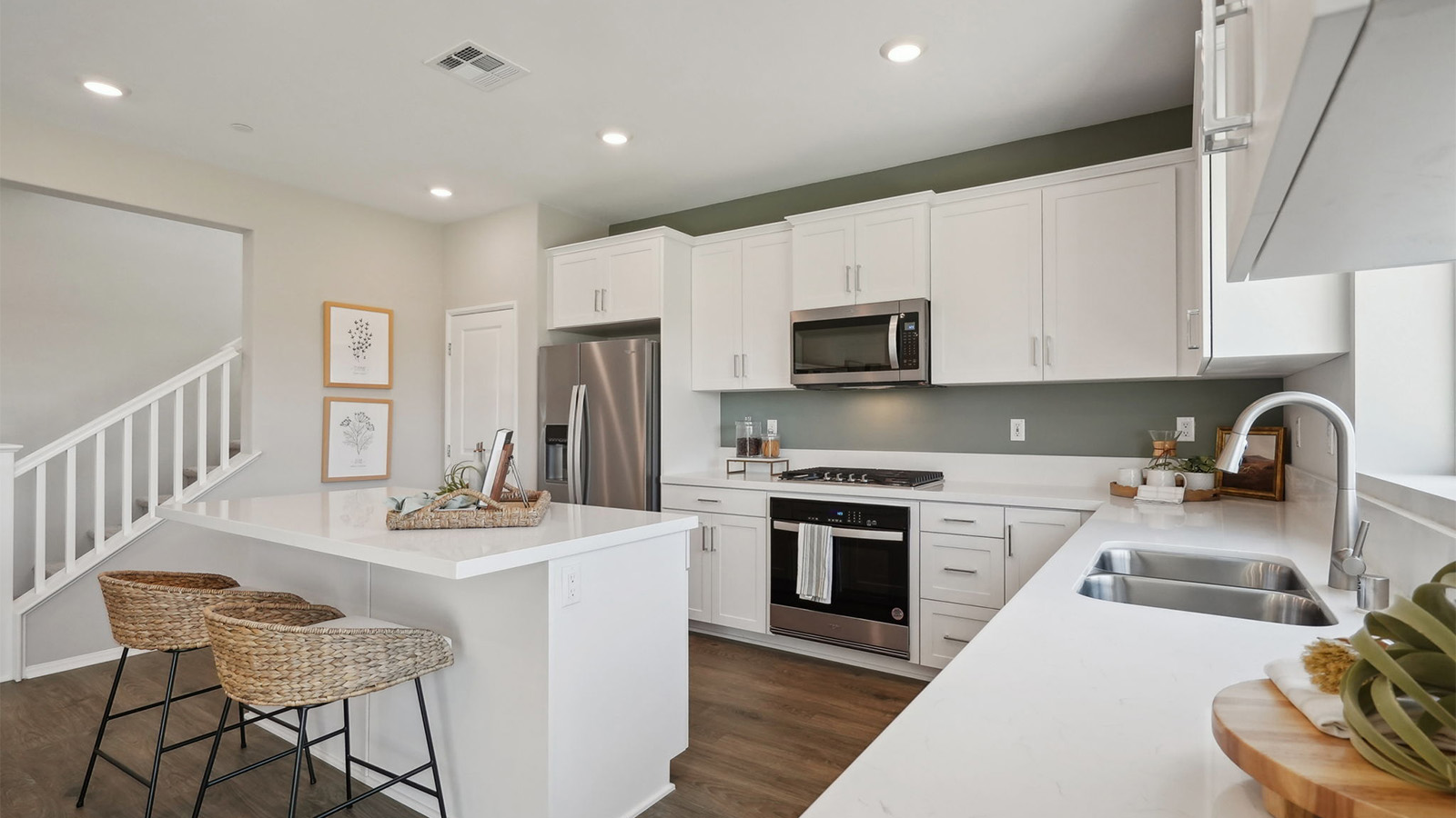 Modern kitchen with white cabinets quartz countertops and stainless steel appliances