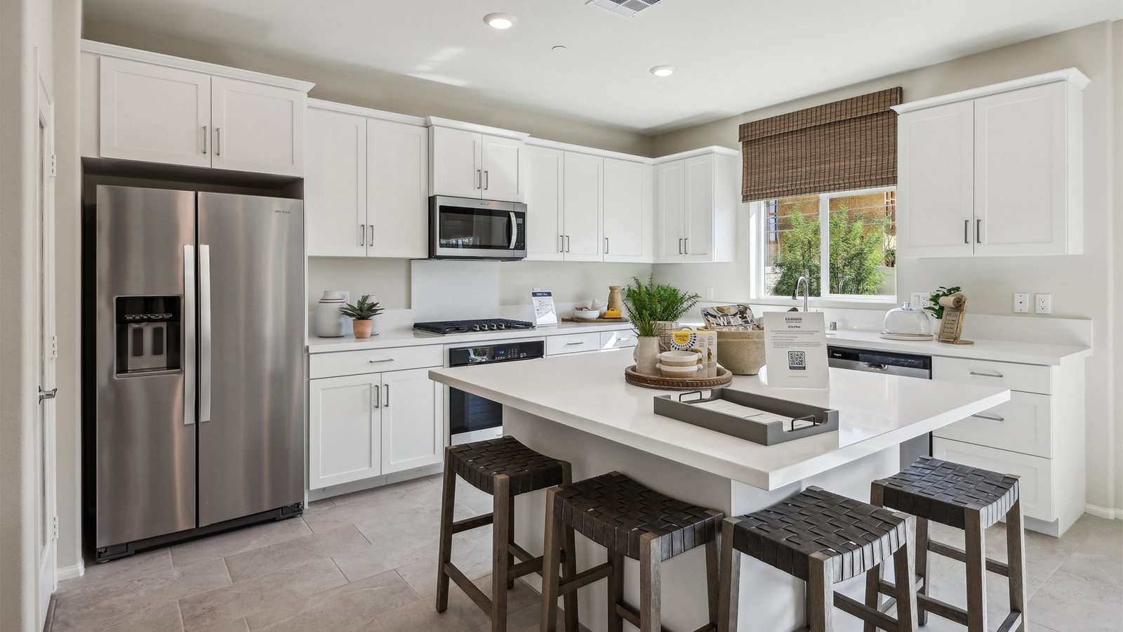 Modern kitchen with white cabinets quartz countertops and stainless steel appliances