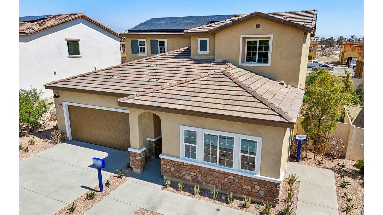 Two-story Tuscan home with stone veneer and two-car garage