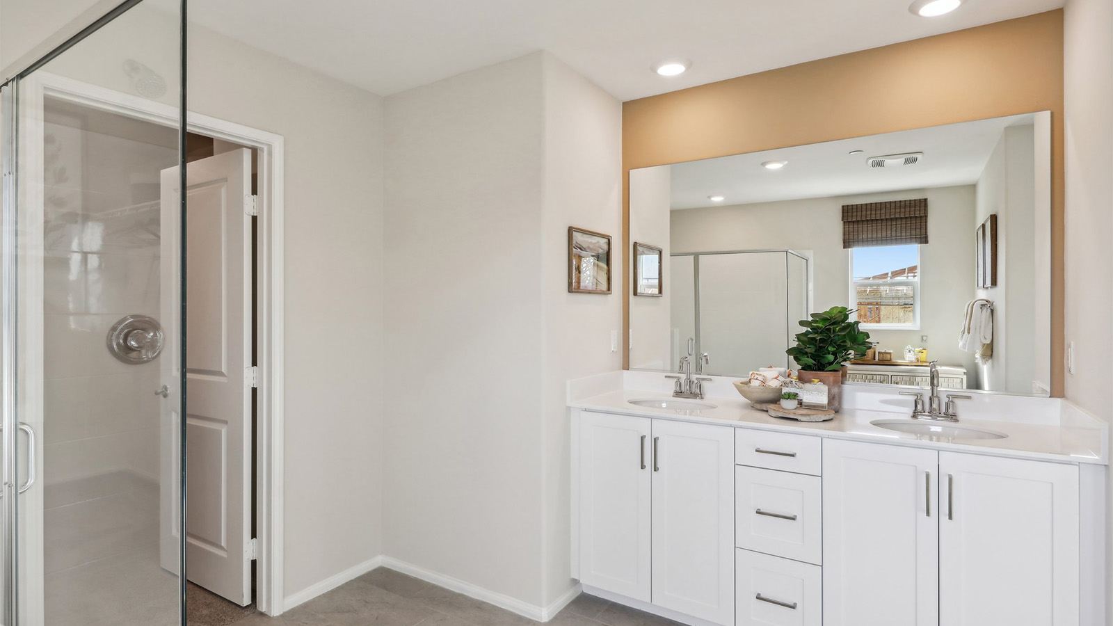 Primary bathroom with dual vanities and shower