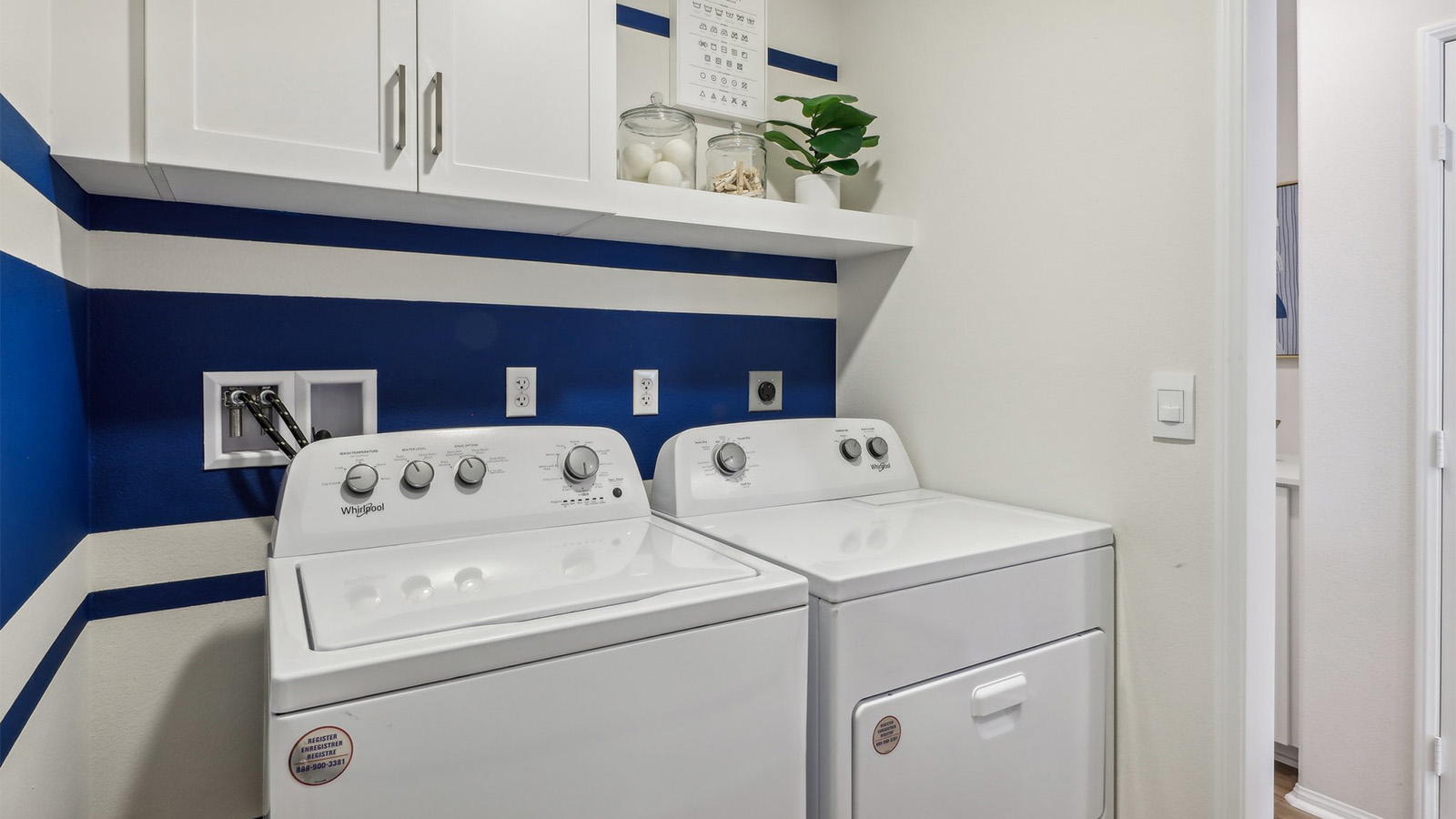 Laundry room with upper cabinet and shelf and washer and dryer