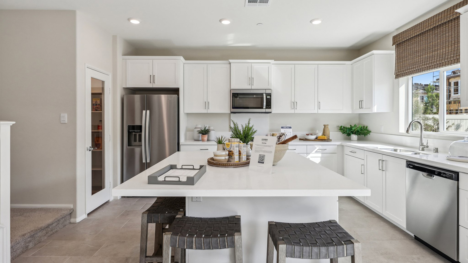 Modern kitchen with white cabinets quartz countertops and stainless steel appliances