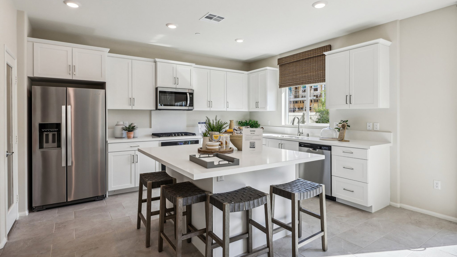 Modern kitchen with white cabinets quartz countertops and stainless steel appliances