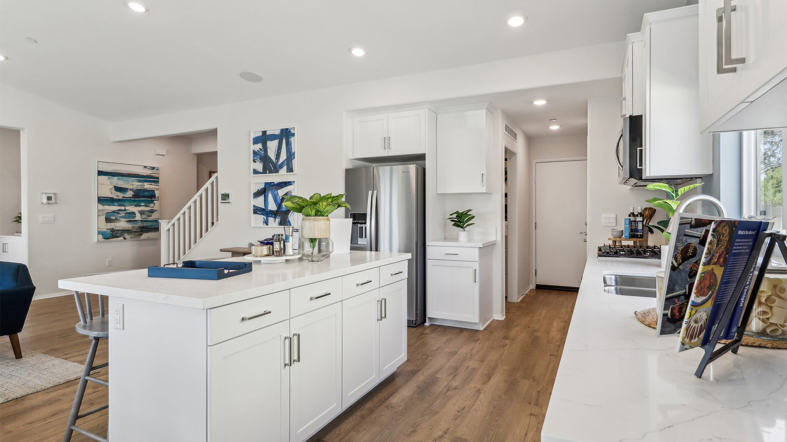 Modern kitchen with white cabinets quartz countertops and stainless steel appliances