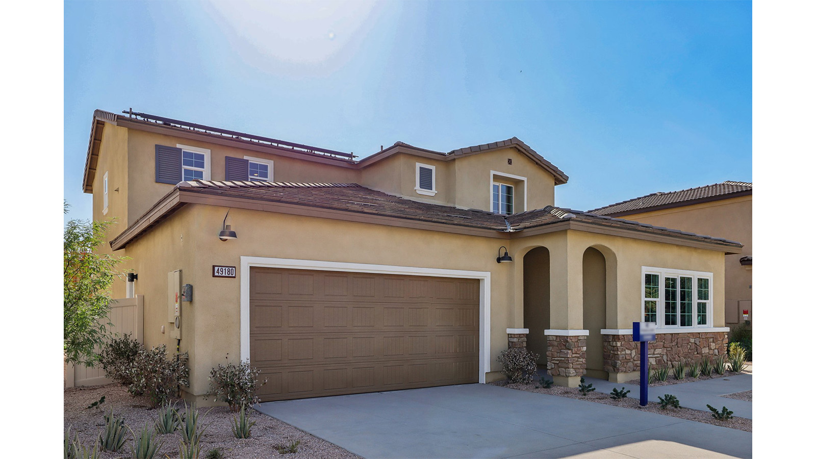 Two-story Tuscan home with stone veneer and two-car garage