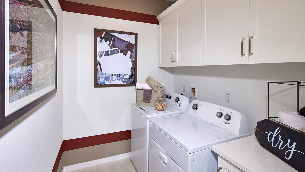 Laundry room with washer, dyer, and upper white cabinets