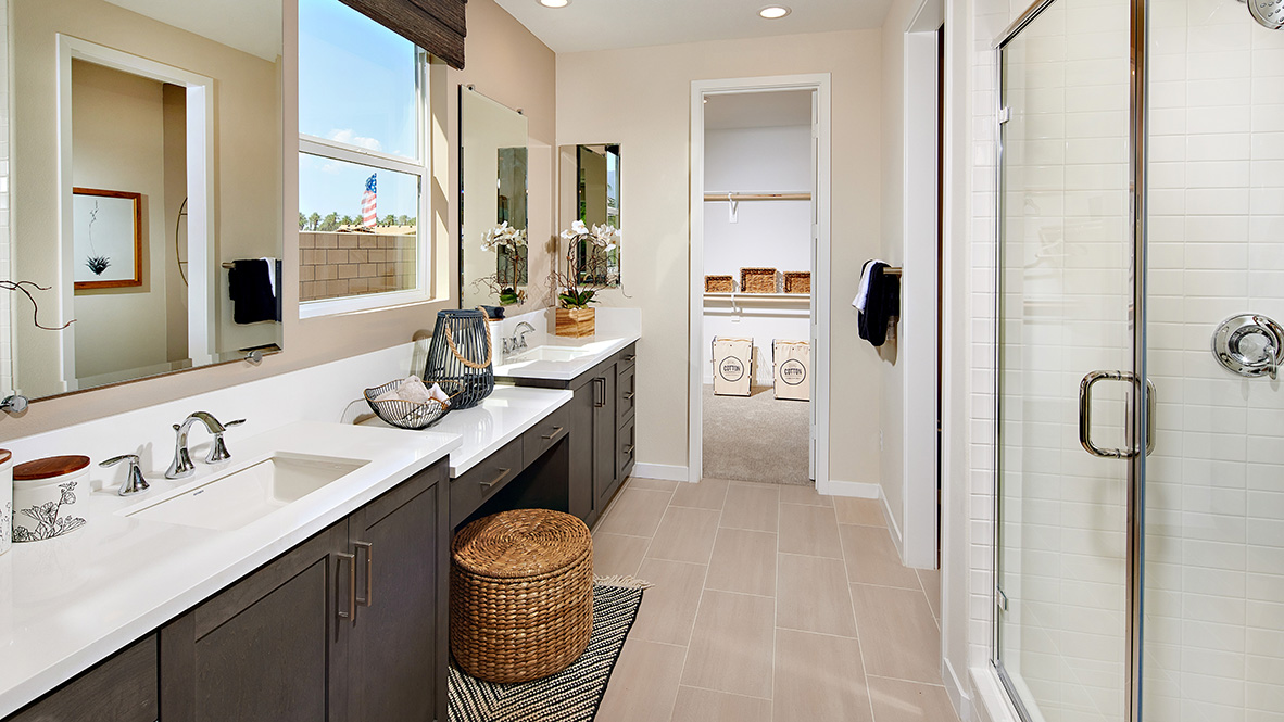 Primary bathroom with his and hers sink, vanity, walk-in closet, and shower