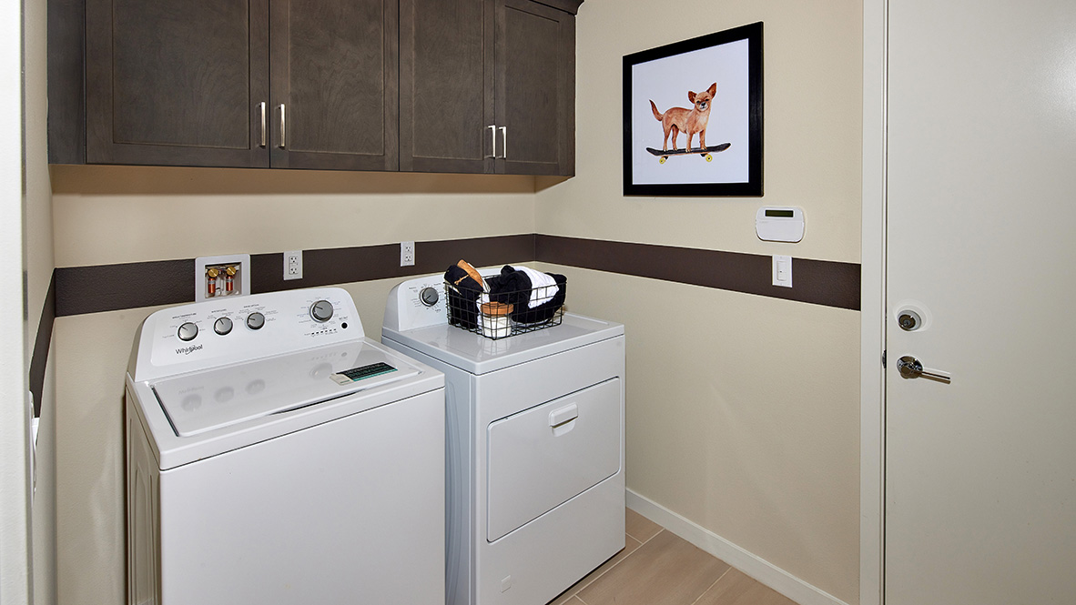 Laundry room with washer, dyer, and upper cabinets