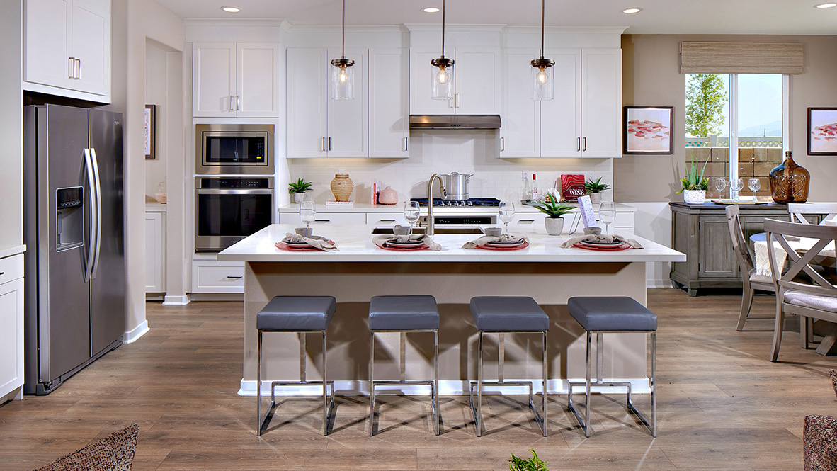Modern kitchen with white cabinets quartz countertops and stainless steel appliances