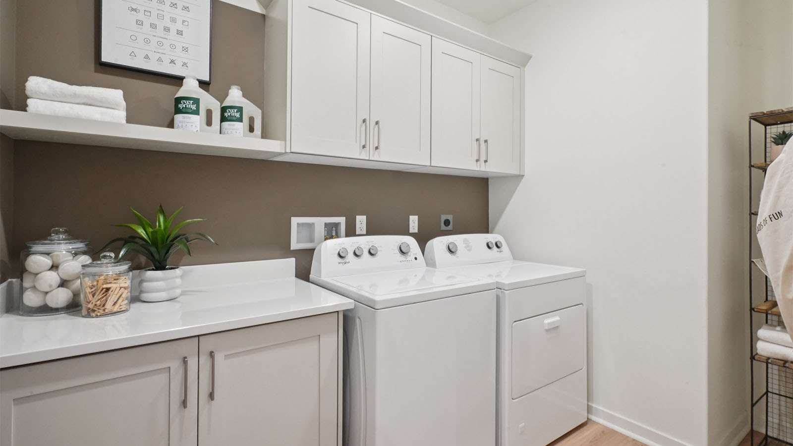 Laundry room with lower and upper cabinets and washer and dryer