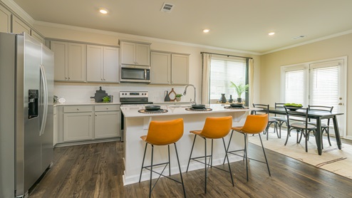 Breakfast bar with grey cabinets and stainless steel appliances.