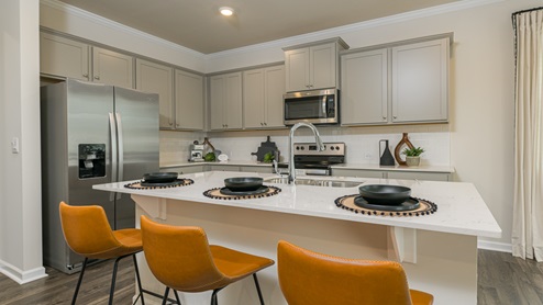 Breakfast bar with grey cabinets and stainless steel appliances.