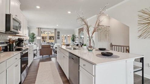 White cabinets with white quartz countertops and subway tile