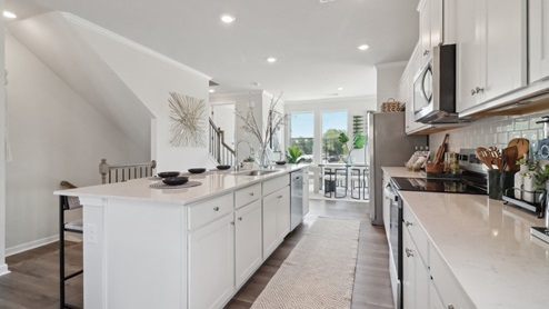 White cabinets with white quartz countertops and subway tile